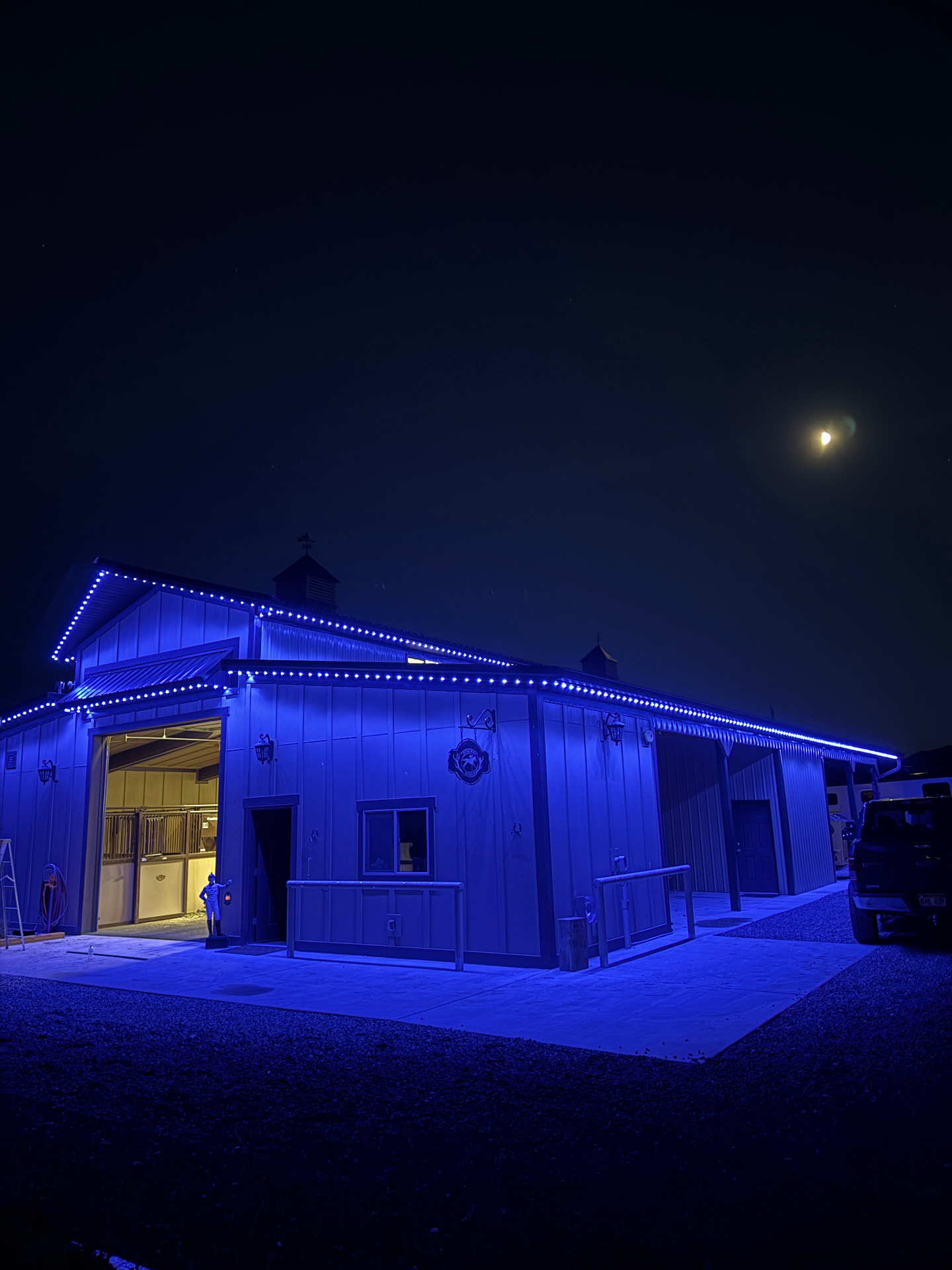 Barn outlined in blue permanent LED lighting at night