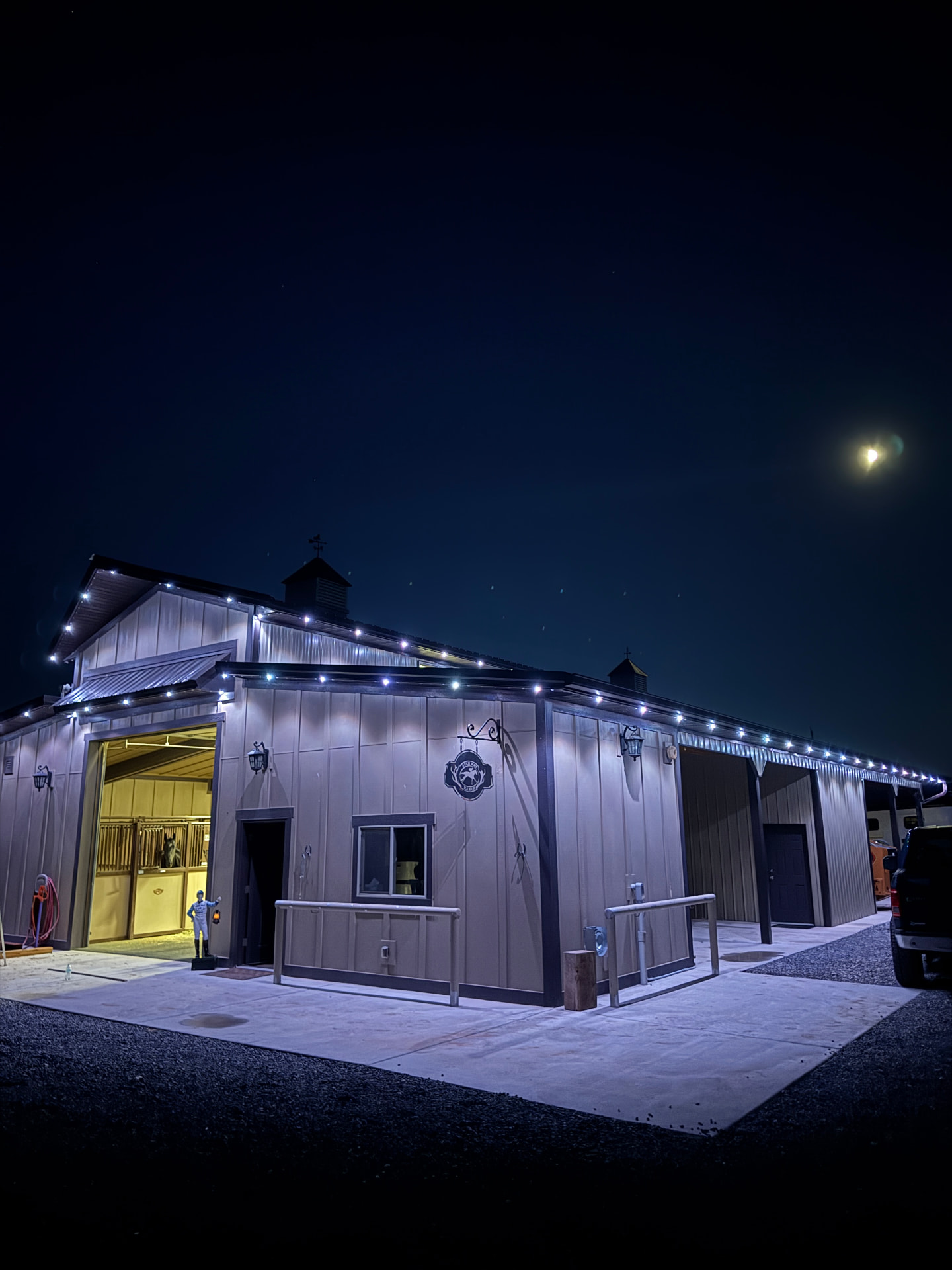 Barn outlined in warm white permanent LED lighting at night