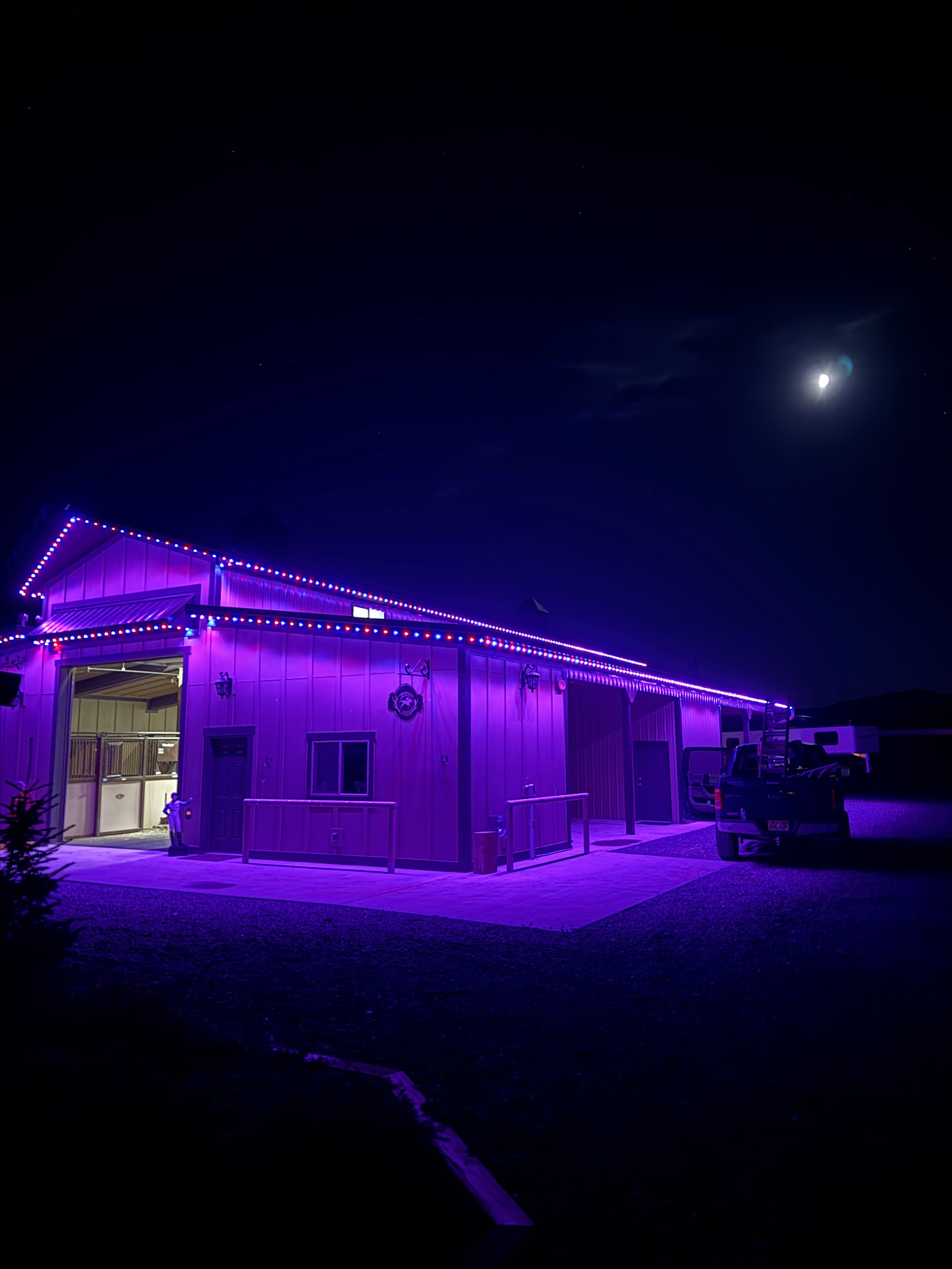 Barn outlined in purple permanent LED lighting at night